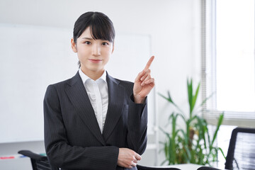 オフィスで指差しで説明をする日本人女性ビジネスウーマン