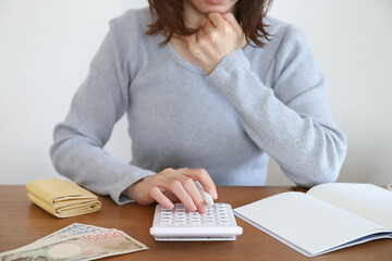 電卓を使い家計に悩む女性