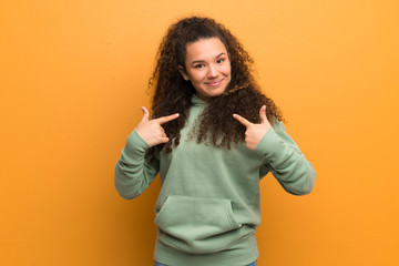 Teenager girl over ocher wall with surprise facial expression