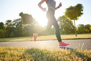Low section of young woman running in the park