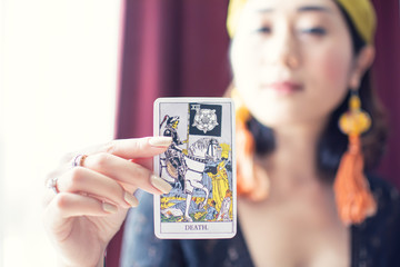 Tarot card of Death with blur background of gypsy or bohemian woman