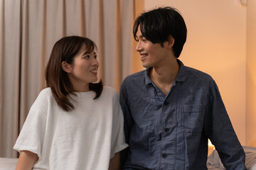 寝室で2人寄り添う日本人夫婦