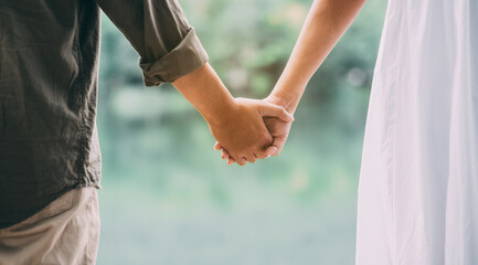 close-up of a young couple holding hands in nature