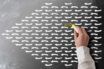 striving against the stream or swim against the tide concept with arrows on blackboard